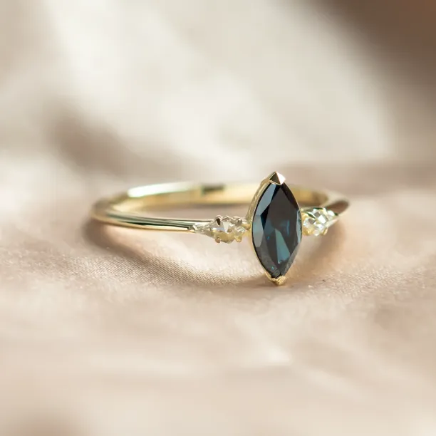 Angled view of the ADINA gold ring with a blue marquise diamond