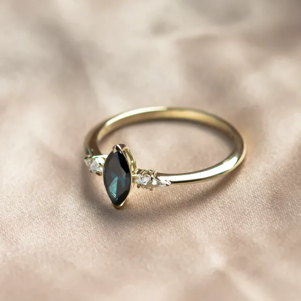 Angled view of the ADINA gold ring with its blue marquise diamond