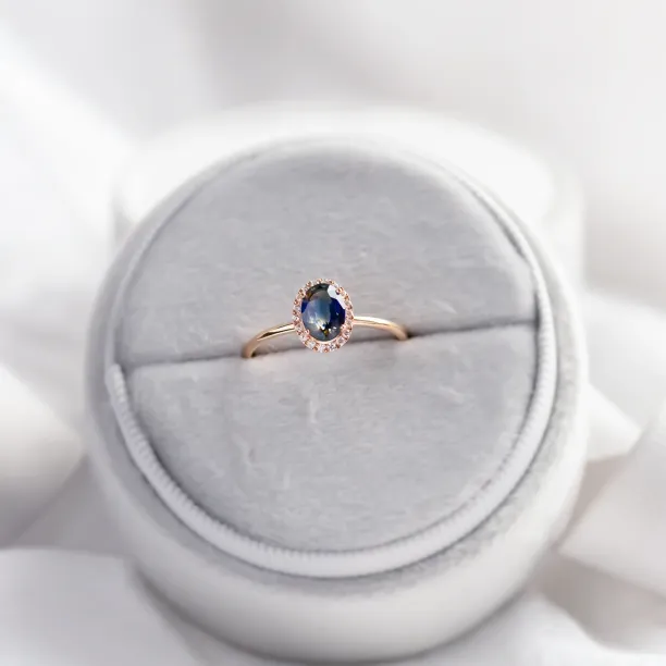ZARIA halo ring with teal sapphire and diamonds, angled product view