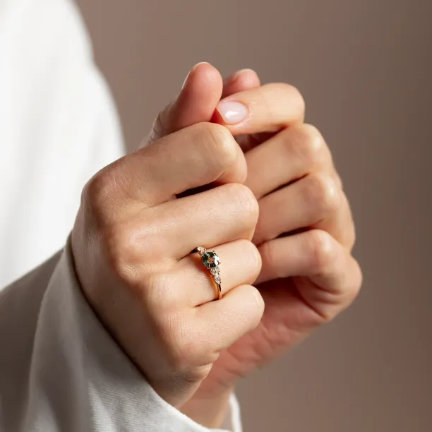 MAIDEN engagement ring with natural green sapphire and diamonds worn on a hand