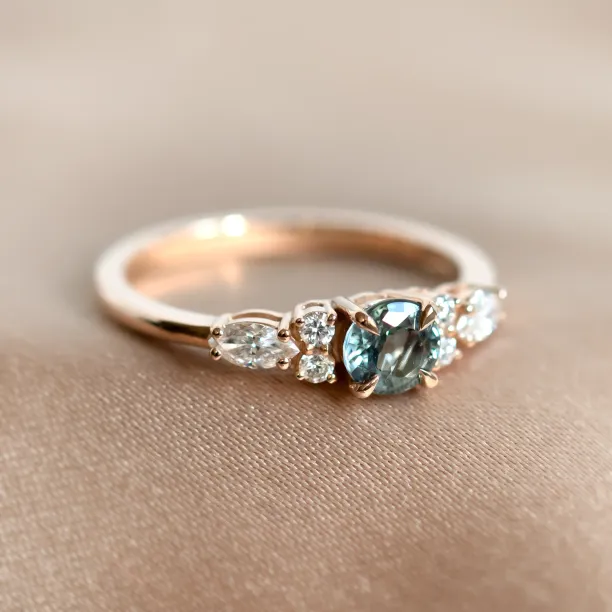 Close-up of the MAIDEN gold ring with green sapphire and side diamonds