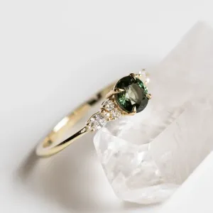 Angled view of the MAIDEN engagement ring with natural green sapphire