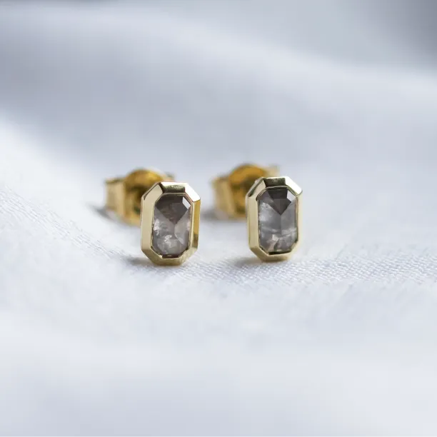 Close-up of NYLA gold stud earrings with salt and pepper diamonds