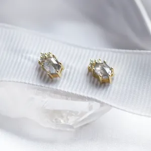 Angled view of TERRA stud earrings with salt and pepper diamonds