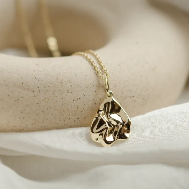 Close-up of the HEARTBEAT gold necklace pendant and chain