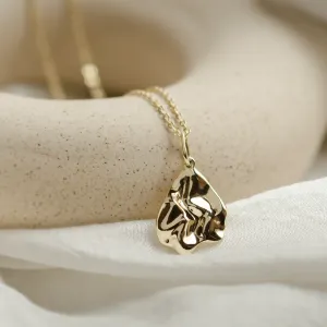 Close-up of the HEARTBEAT gold necklace pendant and chain