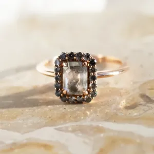 Close-up of the LUCIANA gold engagement ring and its salt and pepper diamond halo