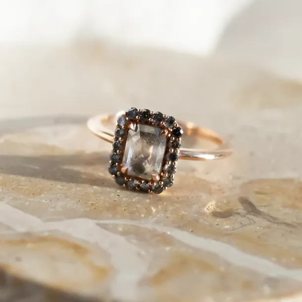 Angled view of the LUCIANA gold engagement ring with a salt and pepper diamond halo