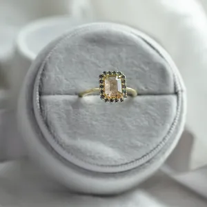 LUCIA gold ring with an emerald-shape center and salt and pepper diamond halo