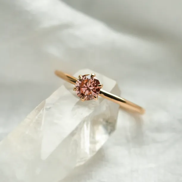 Detailní šikmý pohled na minimalistický zásnubní prsten s růžovým lab grown diamantem