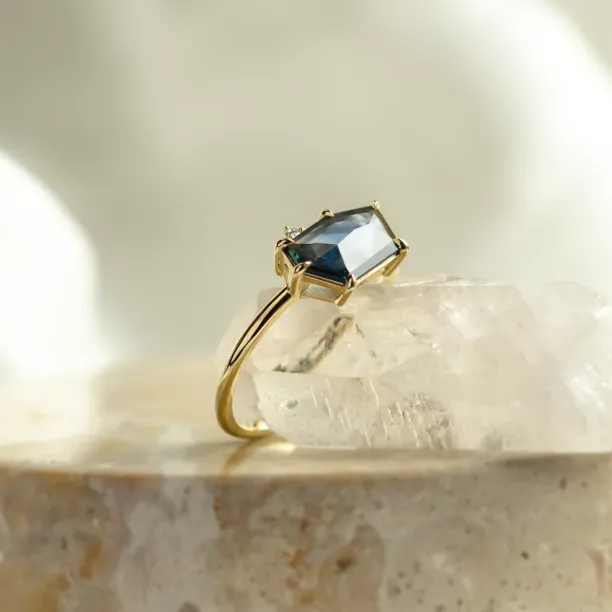 Profile view of the MAGNIFICA gold engagement ring with asymmetrical teal sapphire