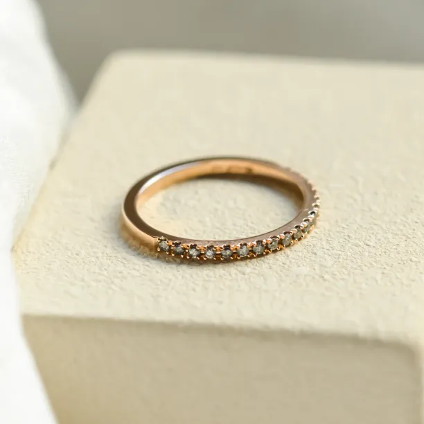 Angled view of DORA gold ring with salt and pepper diamonds across half the band