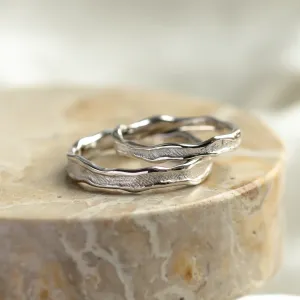 Angled view of SAVANNAH matching wedding rings with textured surfaces