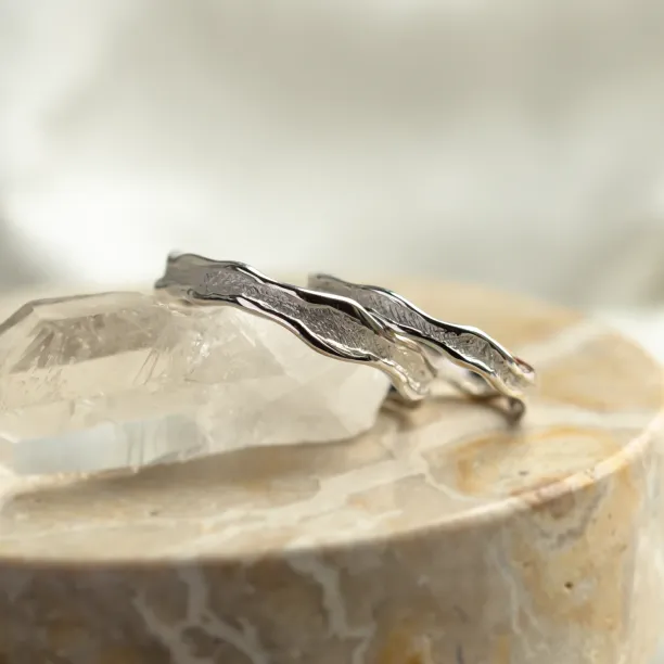 Close-up of SAVANNAH matching wedding rings with irregular textured bands