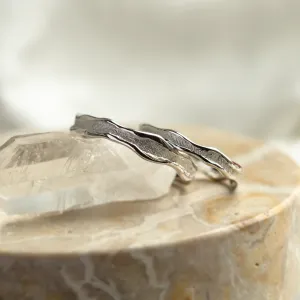 Close-up of SAVANNAH matching wedding rings with irregular textured bands