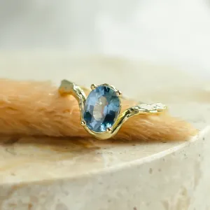 Close-up of KIARA gold ring with oval blue sapphire and branch-like band