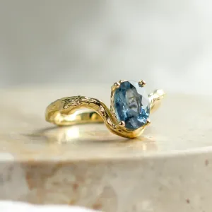 Angled view of KIARA gold ring with oval blue sapphire