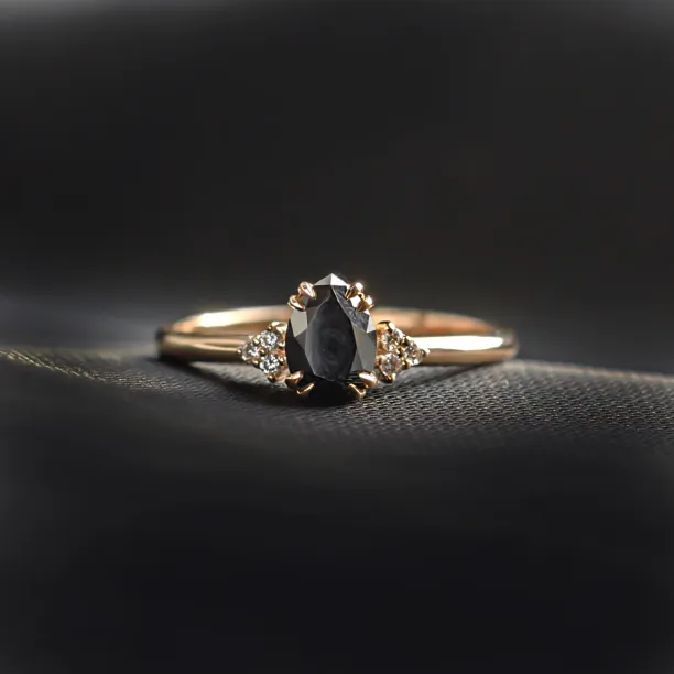 Angled view of the BLACKIE engagement ring with a black pear diamond