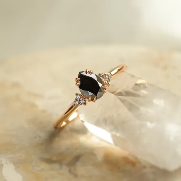 Angled close-up of the BLACKIE ring with a black pear diamond and side diamonds