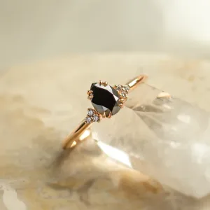 Angled close-up of the BLACKIE ring with a black pear diamond and side diamonds