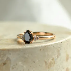 Close-up of the BLACKIE engagement ring with a black pear diamond and natural side diamonds