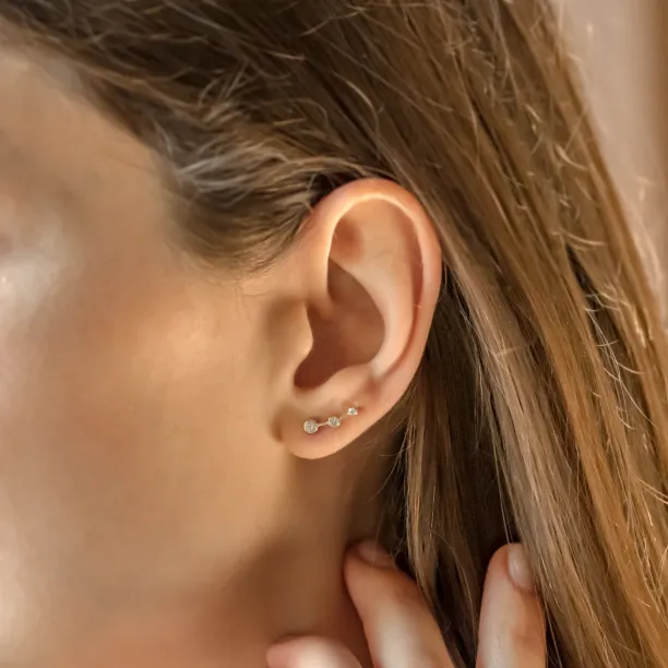 Close-up of a MARIAN diamond earring worn on the ear