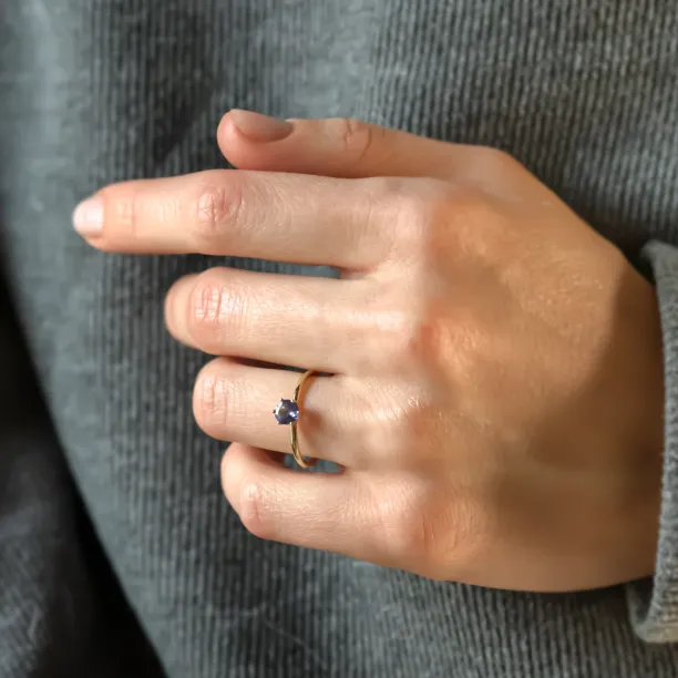 Angled view of the TANJA tanzanite ring worn on a hand