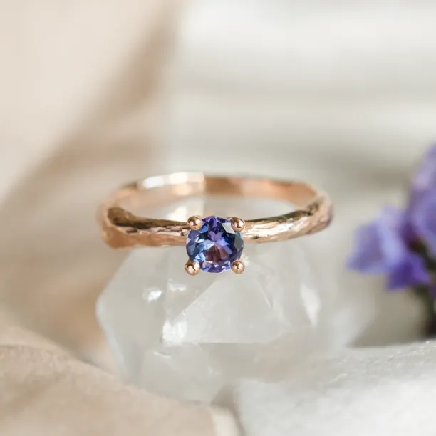 Angled close-up of the DREMIS gold tree branch ring with tanzanite