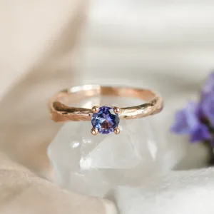 Angled close-up of the DREMIS gold tree branch ring with tanzanite