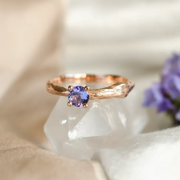 Close-up of the DREMIS gold tree branch ring and faceted tanzanite