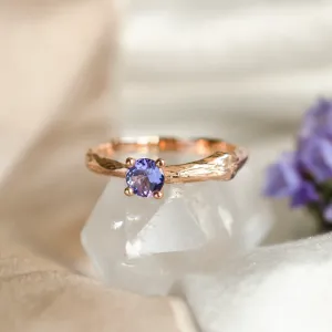Close-up of the DREMIS gold tree branch ring and faceted tanzanite