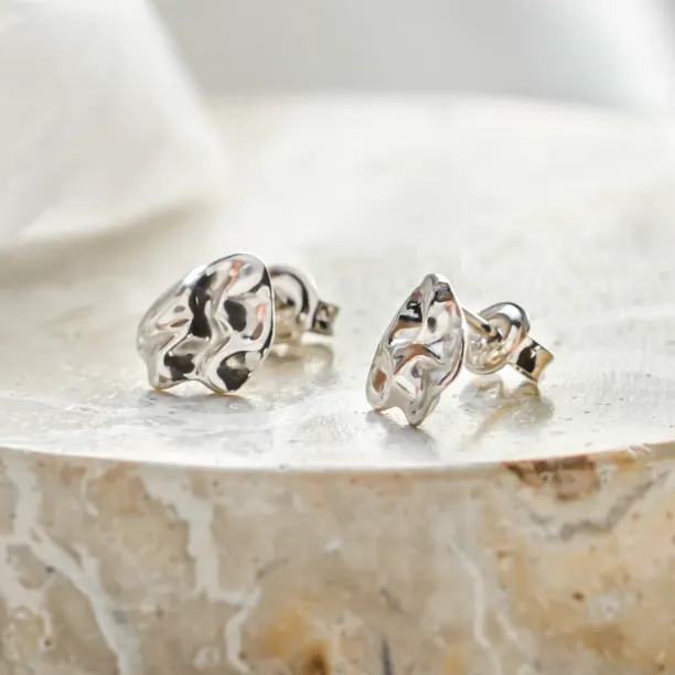 Close-up of CHÉRIE gold heart-shaped earrings