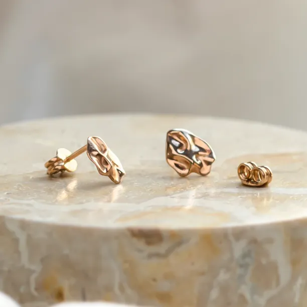 Angled view of CHÉRIE gold heart-shaped earrings showing their backs
