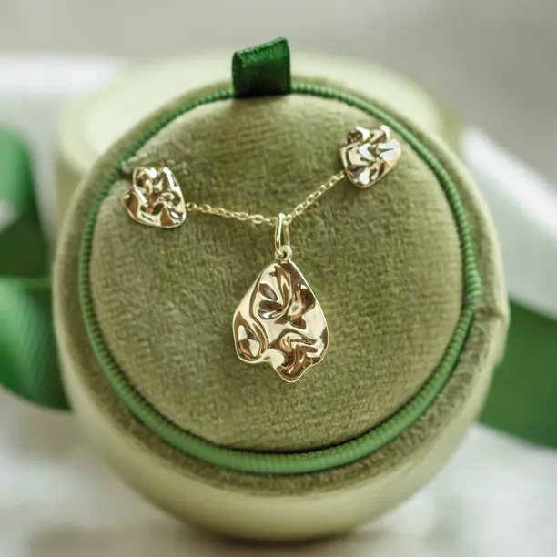 CHÉRIE gold heart-shaped earrings displayed with a pendant