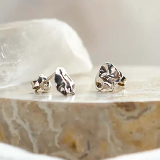 Angled close-up of CHÉRIE gold heart-shaped earrings and backs