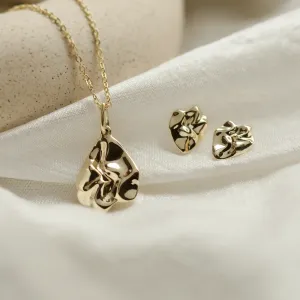 CHÉRIE gold heart-shaped earrings displayed beside a pendant necklace