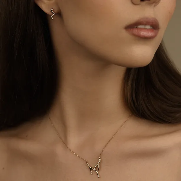 MIGNON wave earring worn on the ear in a close-up