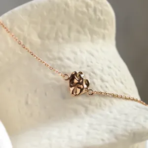 Close-up of the irregular heart-like element on the gold LAURENCE bracelet
