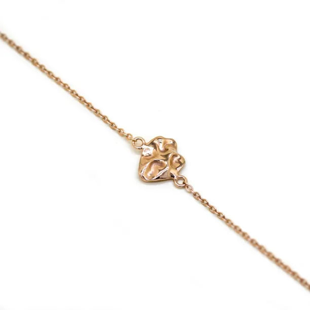 Close-up of the LAURENCE gold bracelet with an irregular heart-like design element
