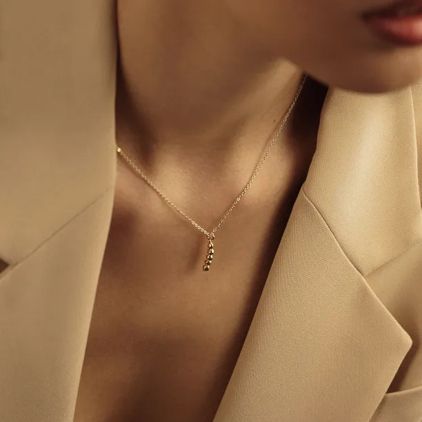 Gold CORINNE necklace with diamond pendant worn on the neck