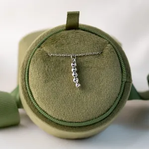 Close-up of the CORINNE necklace pendant on a display cushion