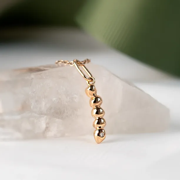 Close-up of the gold CORINNE pendant with diamond