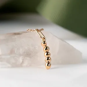 Close-up of the gold CORINNE pendant with diamond