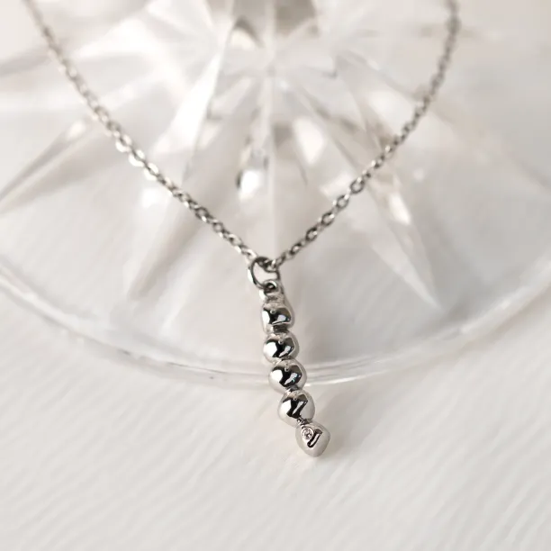 Close-up of the gold CORINNE necklace pendant with a diamond