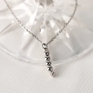 Close-up of the gold CORINNE necklace pendant with a diamond