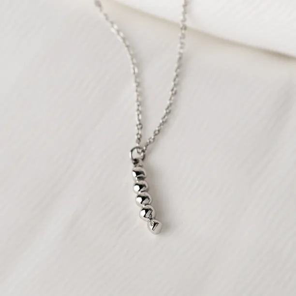 Close-up of the white gold CORINNE necklace pendant with a diamond