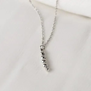 Close-up of the white gold CORINNE necklace pendant with a diamond