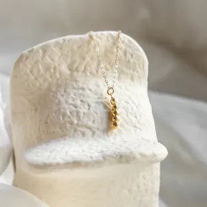 Angled view of the gold CORINNE necklace with its diamond pendant