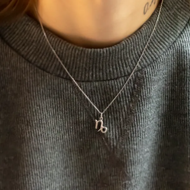 Gold diamond CAPRICORN pendant worn on the neck