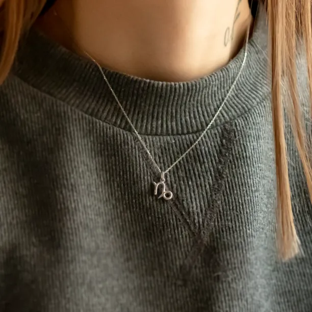 Gold diamond CAPRICORN pendant worn on the neck